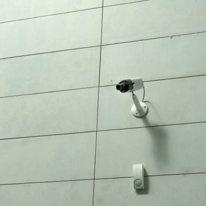 A CCTV camera on a white wall.