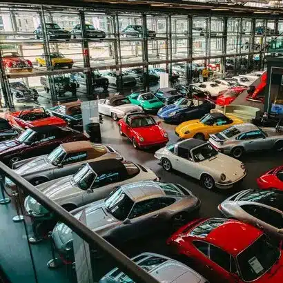 A car showroom with lots of different coloured cars inside.