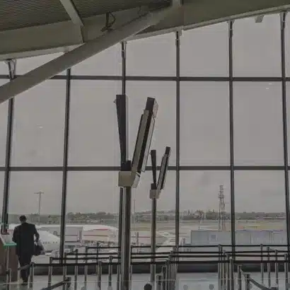 An empty airport departures lounge, looking out of the window onto planes outside.