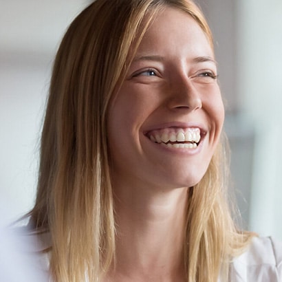 A young white woman with blonde hair smiling.