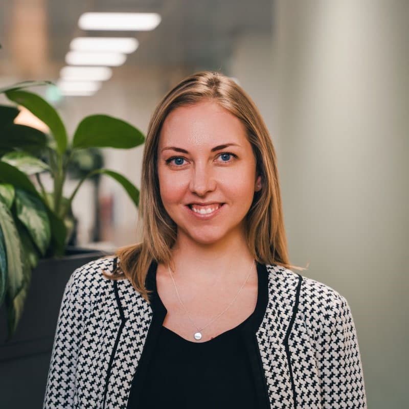 Anine Fahy standing in an office next to green plants.