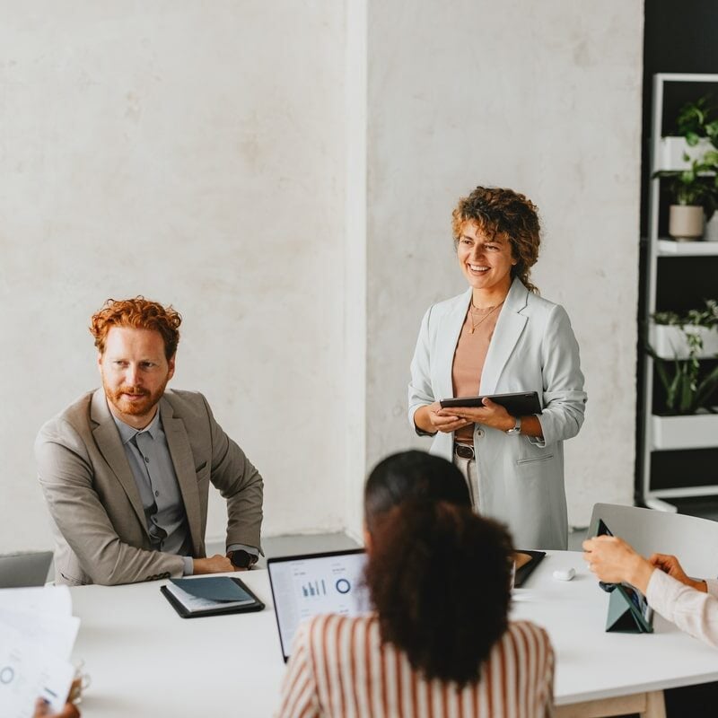 A diverse group of business professionals having a productive meeting in a modern office environment, collaborating on various projects and ideas.